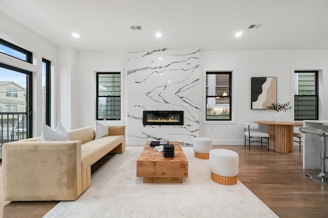 living room featuring a premium fireplace and hardwood / wood-style floors