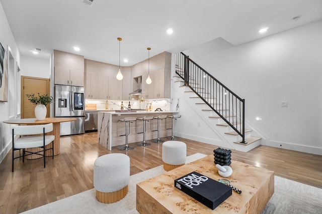 living room with sink and light hardwood / wood-style floors