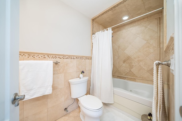 full bathroom featuring tile patterned floors, a wainscoted wall, toilet, tile walls, and shower / bath combination with curtain