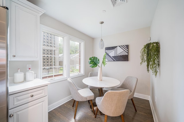 dining room with dark wood finished floors, visible vents, and baseboards