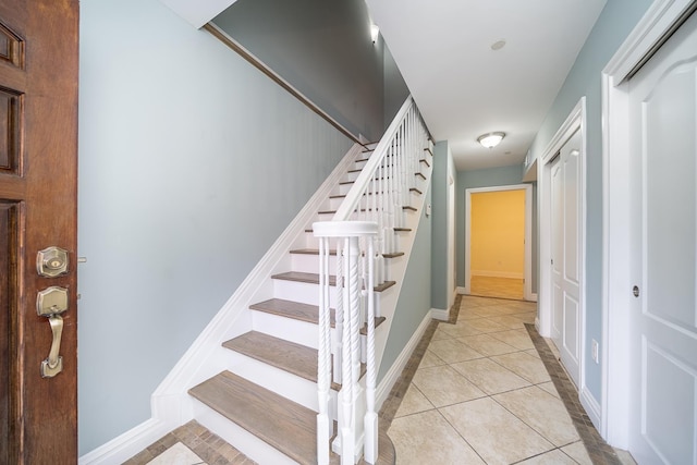 stairs with tile patterned floors and baseboards