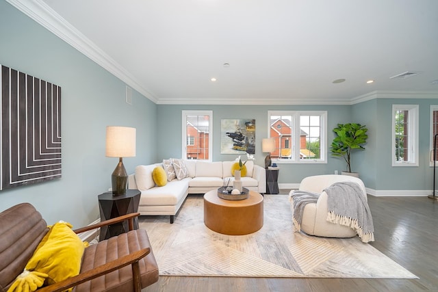 living area with wood finished floors, a healthy amount of sunlight, baseboards, and ornamental molding