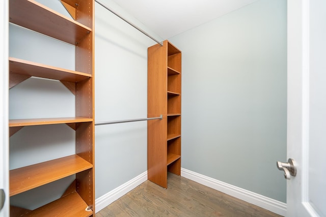 walk in closet with wood finished floors