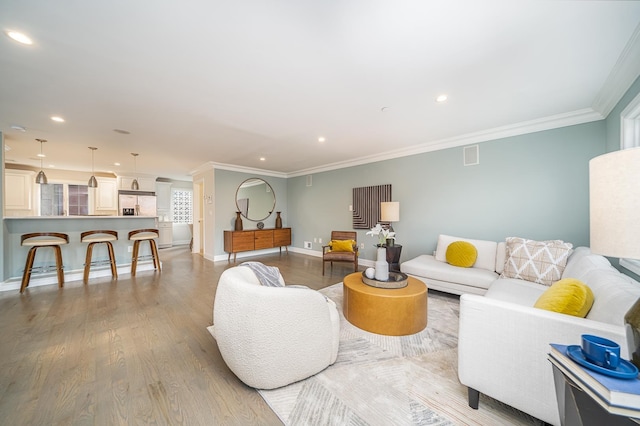 living area featuring recessed lighting, crown molding, baseboards, and wood finished floors