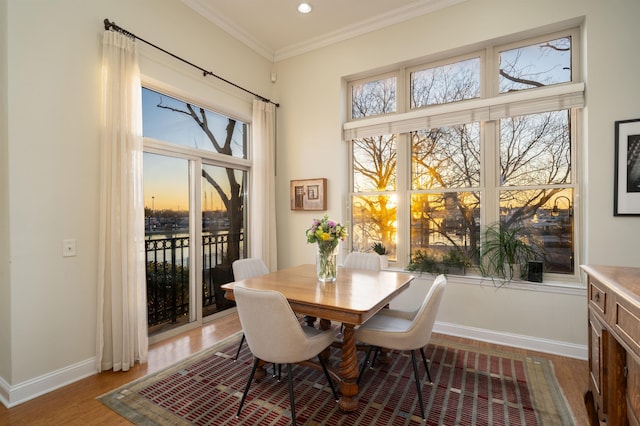 dining room featuring wood finished floors, baseboards, ornamental molding, and recessed lighting