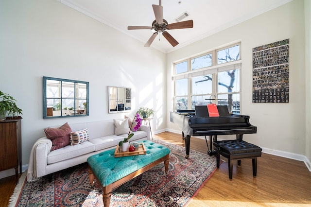 living area featuring baseboards, wood finished floors, and crown molding