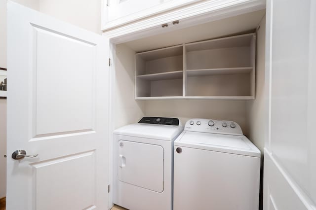 clothes washing area featuring washer and dryer and laundry area