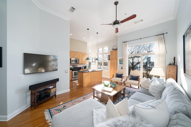 living room featuring visible vents, wood finished floors, and ornamental molding