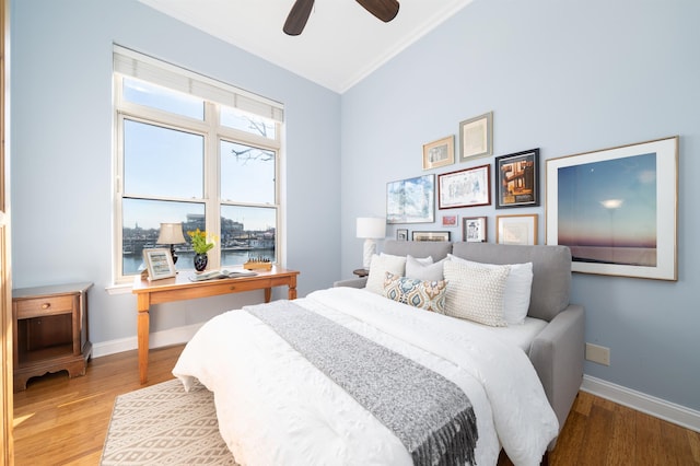 bedroom featuring baseboards, light wood-style floors, and a ceiling fan