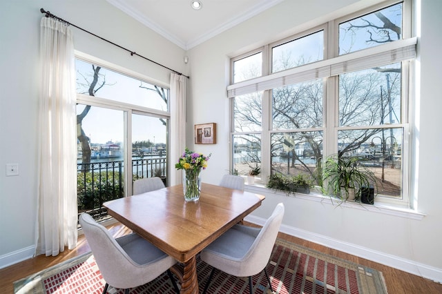 dining area with crown molding, wood finished floors, and baseboards