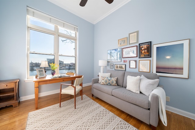 office area with baseboards, light wood finished floors, and ceiling fan