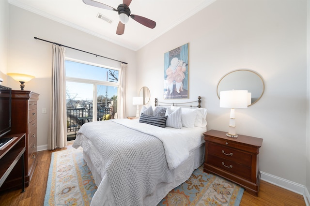 bedroom with access to exterior, light wood-type flooring, visible vents, and ornamental molding