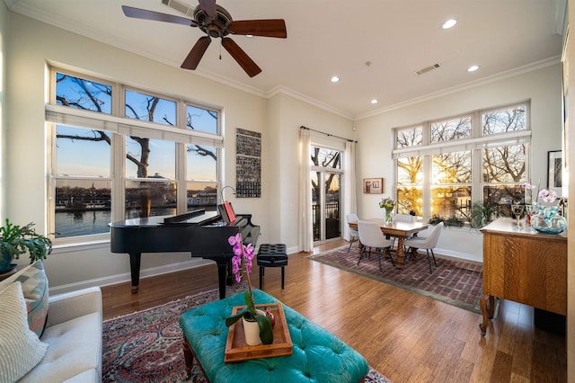 sitting room featuring wood finished floors, baseboards, visible vents, recessed lighting, and ornamental molding