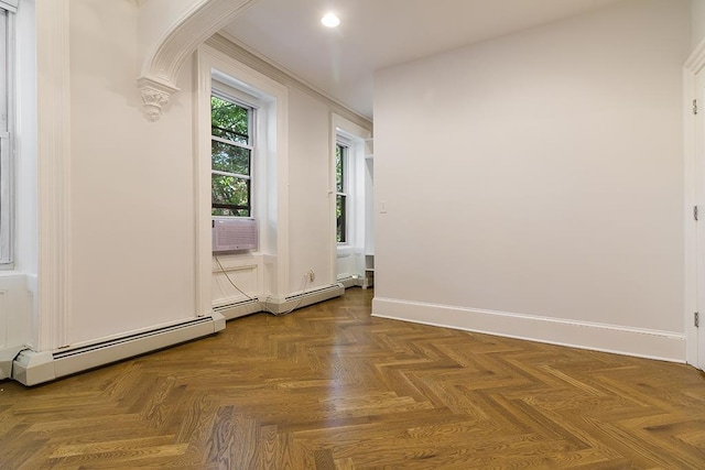 spare room featuring cooling unit, arched walkways, baseboards, baseboard heating, and ornate columns