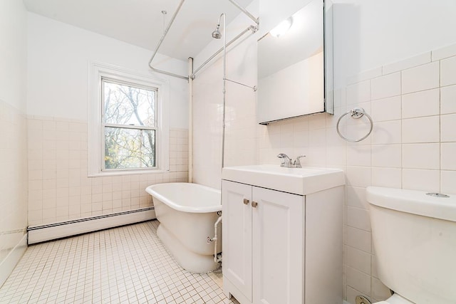 full bath with toilet, a baseboard heating unit, tile walls, a soaking tub, and vanity