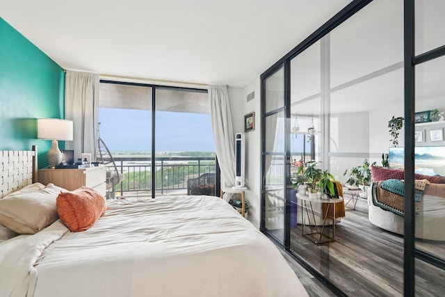 340 Harmon Cove Tower 340, Secaucus, NJ 07094 - bedroom featuring expansive windows, access to outside, wood finished floors, and a water view