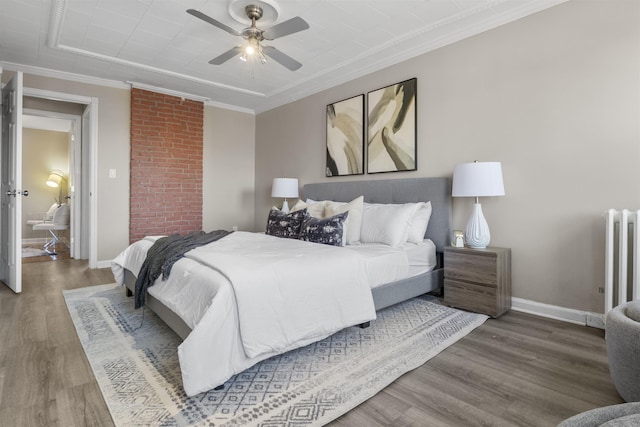 bedroom featuring radiator, ornamental molding, ceiling fan, and hardwood / wood-style flooring