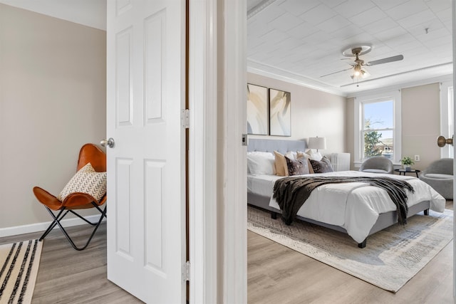 bedroom featuring ornamental molding, ceiling fan, and wood-type flooring