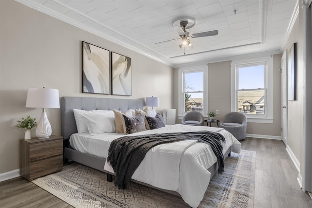 bedroom with ceiling fan, crown molding, and hardwood / wood-style floors