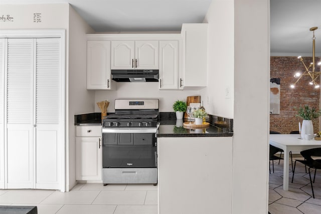 kitchen with gas stove, white cabinetry, light tile patterned floors, and a notable chandelier