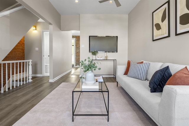 living room featuring ceiling fan and dark hardwood / wood-style flooring