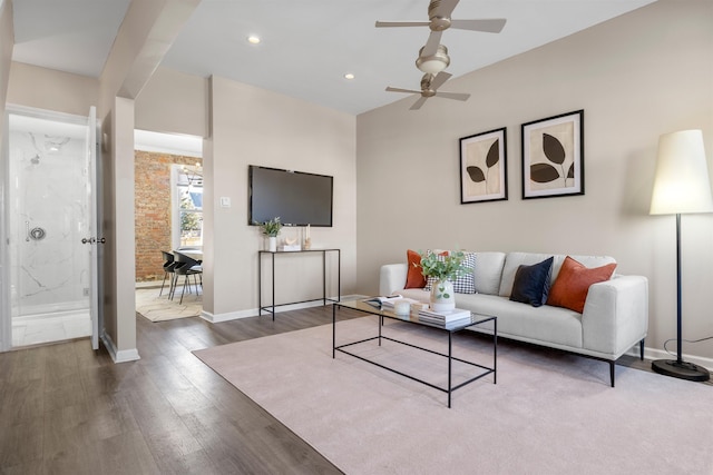 living room featuring ceiling fan and dark hardwood / wood-style floors