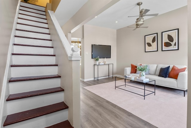 living room featuring ceiling fan with notable chandelier and wood-type flooring