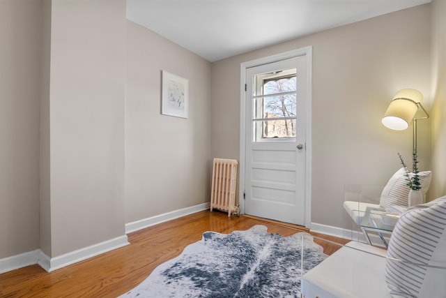 entrance foyer with radiator and hardwood / wood-style floors