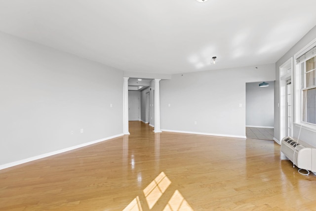 unfurnished room with radiator heating unit and light hardwood / wood-style flooring