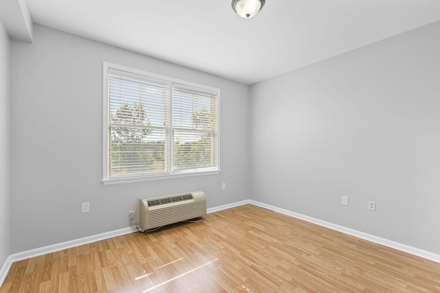 empty room featuring hardwood / wood-style floors and a wall mounted air conditioner