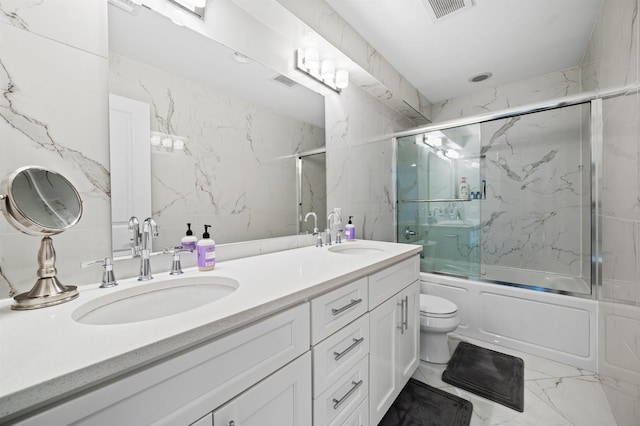 full bathroom featuring bath / shower combo with glass door, vanity, and toilet