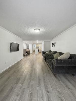 living room featuring hardwood / wood-style flooring, ornamental molding, and a textured ceiling