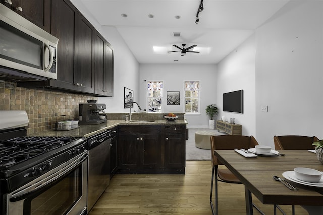 139 Morris St Unit 7, Jersey City, NJ 07302 - kitchen with stainless steel appliances, light wood-style flooring, a sink, backsplash, and a peninsula