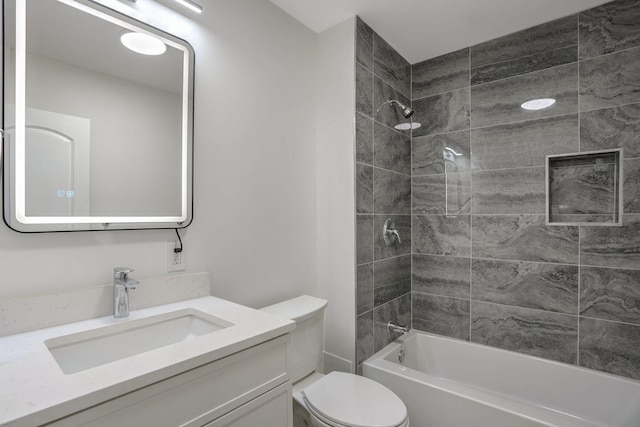 full bathroom featuring toilet, vanity, and tiled shower / bath