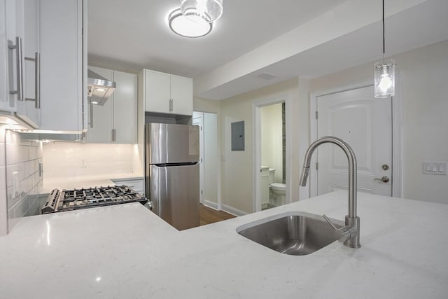 kitchen featuring light stone countertops, sink, stainless steel appliances, tasteful backsplash, and white cabinets