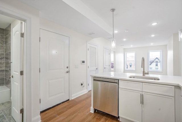 kitchen featuring white cabinets, dishwasher, sink, and decorative light fixtures