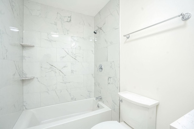 bathroom with tiled shower / bath combo and toilet