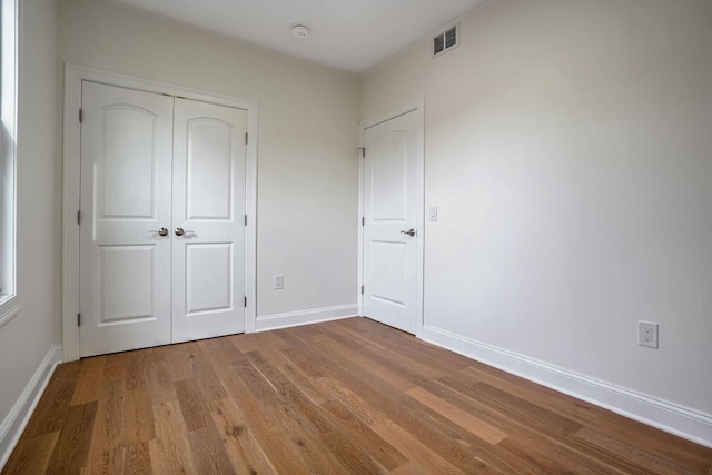 unfurnished bedroom with light wood-type flooring and a closet