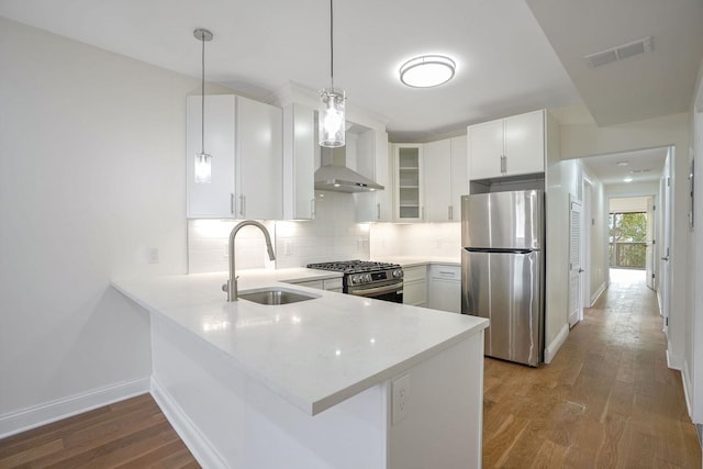 kitchen with white cabinetry, sink, kitchen peninsula, pendant lighting, and appliances with stainless steel finishes