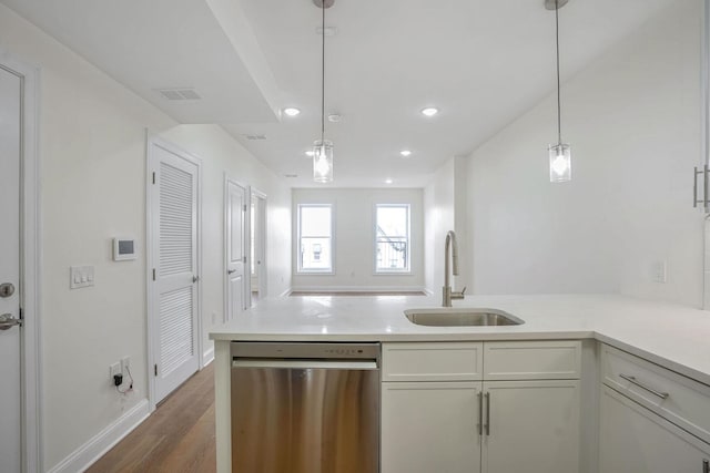 kitchen with pendant lighting, dishwasher, dark wood-type flooring, sink, and kitchen peninsula