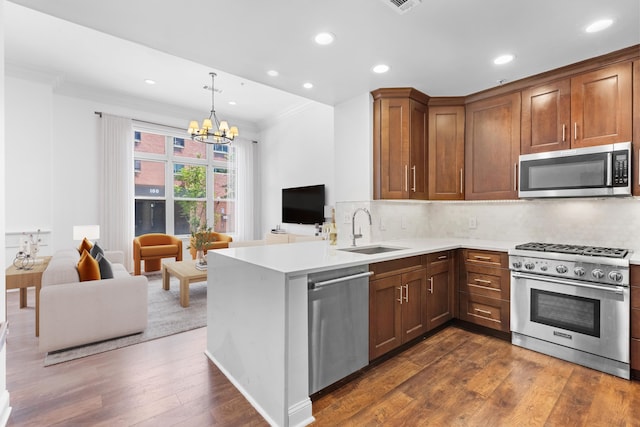 15 Warren St Unit 102, Jersey City, NJ 07032 - kitchen featuring stainless steel appliances, a sink, ornamental molding, open floor plan, and a chandelier