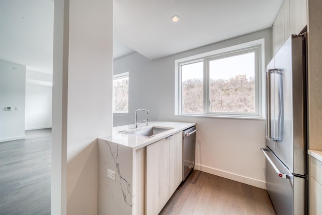 800 Ave At Port Imperial Unit 323, Weehawken, NJ 07086 - kitchen featuring appliances with stainless steel finishes, modern cabinets, light wood-style floors, and light stone counters