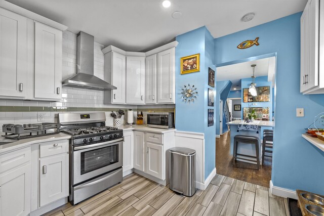 1501 41st St, North Bergen, NJ 07047 - kitchen with wall chimney range hood, appliances with stainless steel finishes, light countertops, and tasteful backsplash