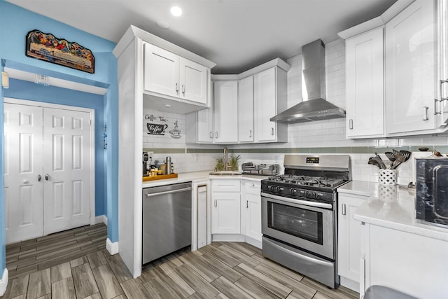 1501 41st St, North Bergen, NJ 07047 - kitchen featuring appliances with stainless steel finishes, wall chimney exhaust hood, light countertops, white cabinets, and recessed lighting
