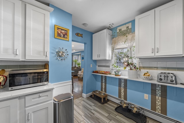 1501 41st St, North Bergen, NJ 07047 - kitchen with stainless steel microwave, baseboard heating, decorative backsplash, and light countertops