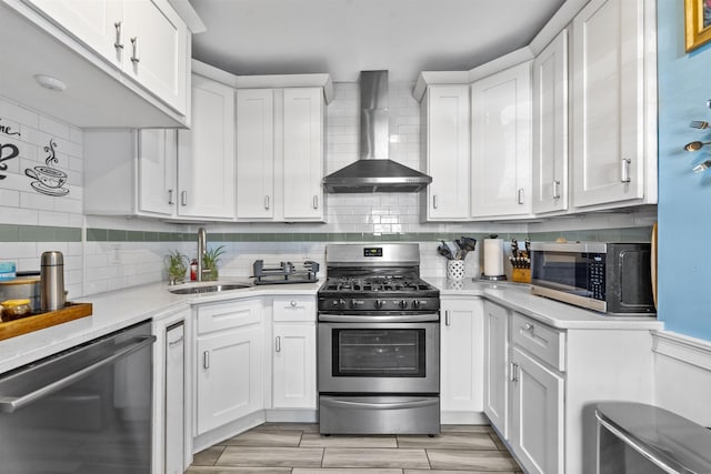 1501 41st St, North Bergen, NJ 07047 - kitchen featuring appliances with stainless steel finishes, wall chimney range hood, light countertops, white cabinets, and decorative backsplash