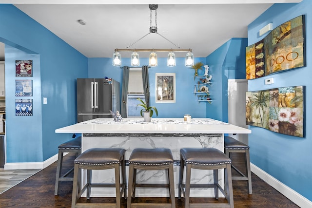 1501 41st St, North Bergen, NJ 07047 - kitchen with freestanding refrigerator, a breakfast bar, dark wood finished floors, and an island with sink