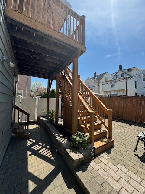 view of patio featuring a fenced backyard, stairs, and a residential view