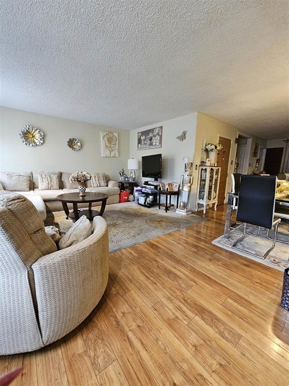 living area featuring a textured ceiling and hardwood / wood-style flooring
