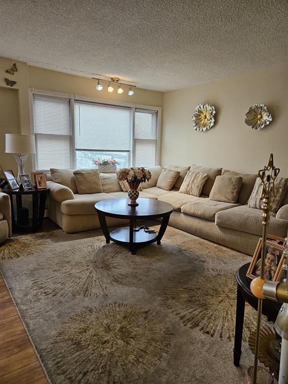 living room with a textured ceiling and wood finished floors